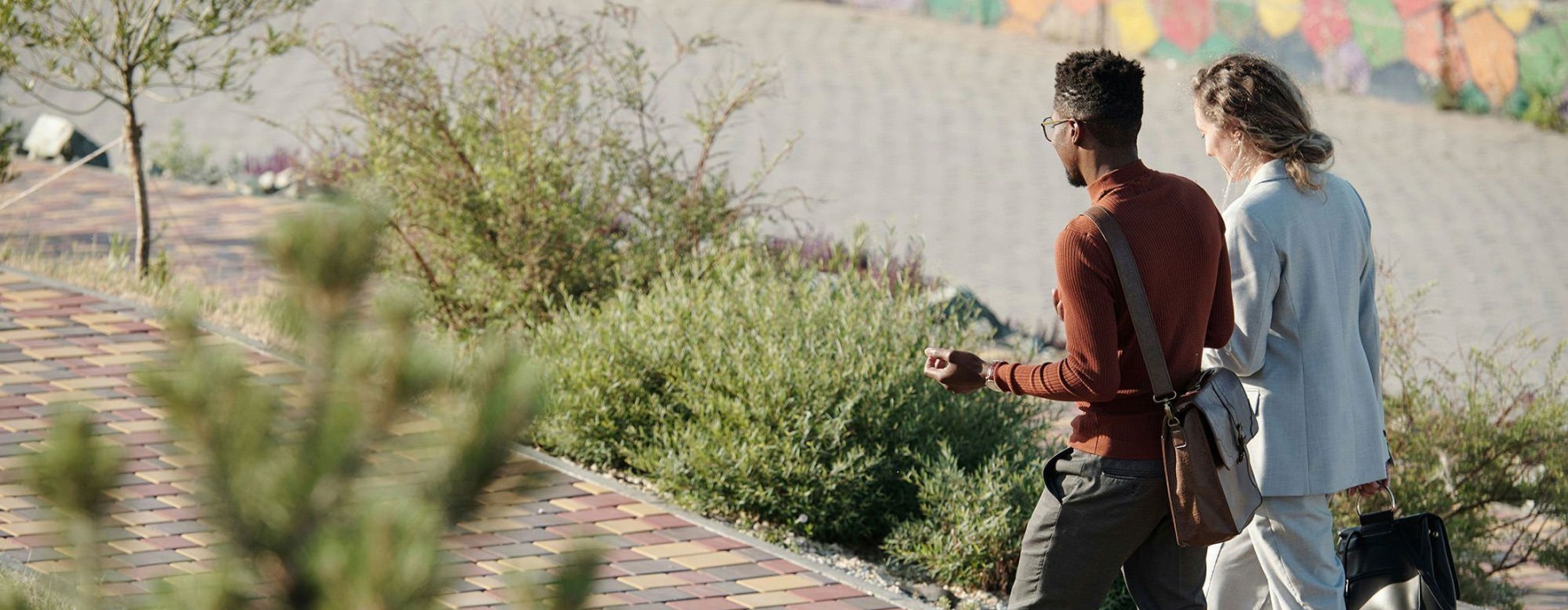 A man and woman walking on a brick sidewalk.